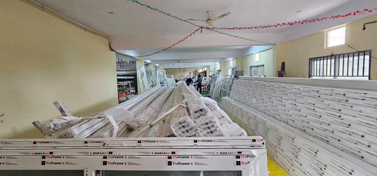 Bundles of white uPVC profiles, each length wrapped in TruFrame-printed protective film